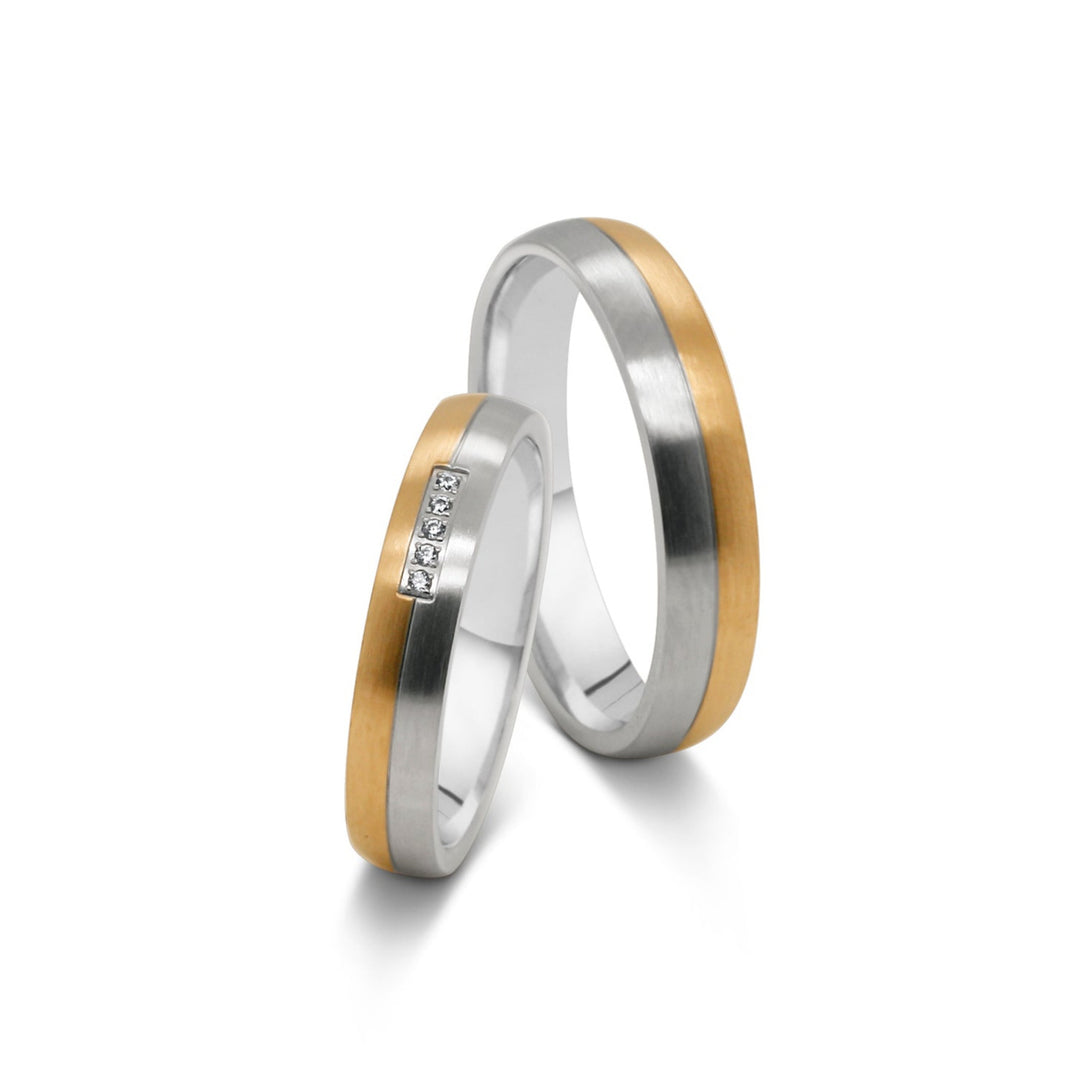 Detailansicht der Edelstahl Partnerringe in Silber und Gold-Optik mit fünf Zirkonia im Damenring.